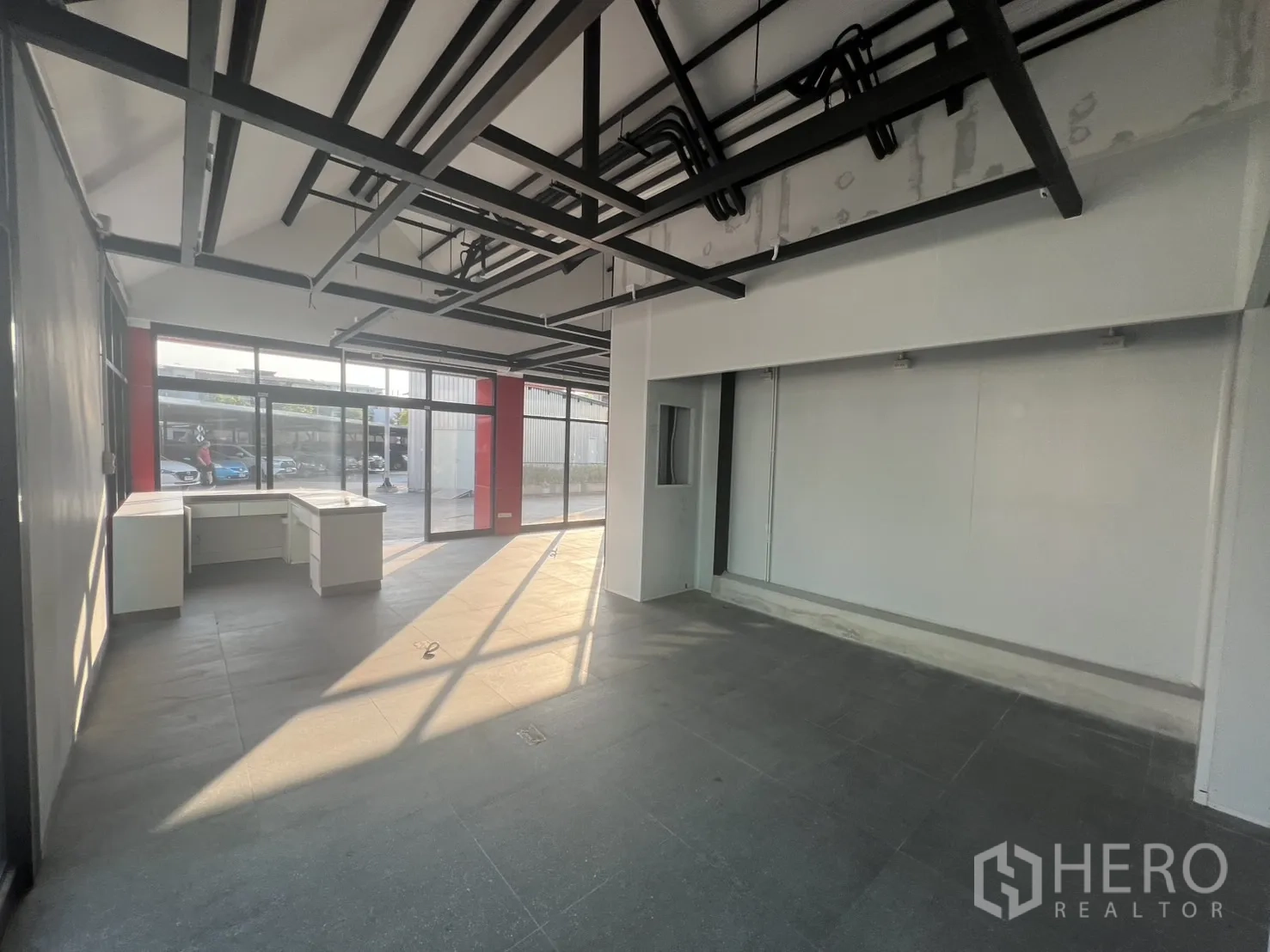 พื้นที่ขายปลีก ให้เช่า - ฮอลล์ยาวพร้อมหน้าต่างกระจก พื้นกระเบื้อง และท่อระบบงานเดินลอย.