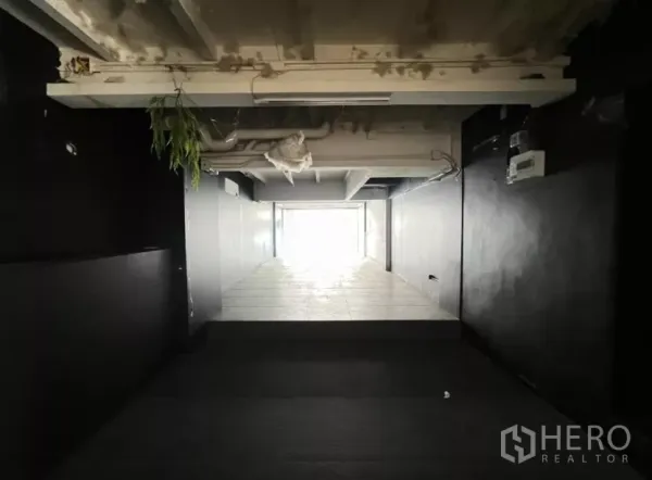 零售空间 出租在Watthana, Bangkok - 狭长型店铺空间，铺瓷砖通向玻璃门面。