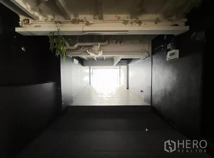 零售空间 出租在Watthana, Bangkok - 狭长型店铺空间，铺瓷砖通向玻璃门面。