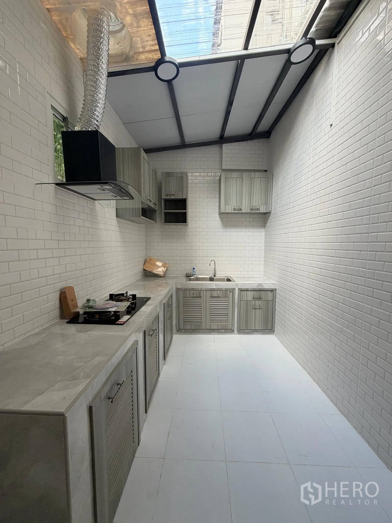 联排别墅 for rent or sale in Yan Nawa, Bangkok - 封闭式厨房，白色地铁砖、灰色柜体与燃气灶