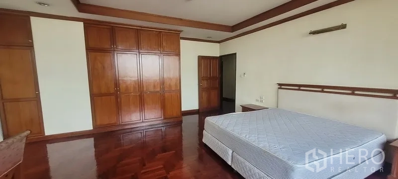 คอนโด ให้เช่าในWatthana, Bangkok - ห้องนอนพร้อมตู้เสื้อผ้าบิวท์อินไม้เต็มผนังและพื้นไม้ขัดเงา