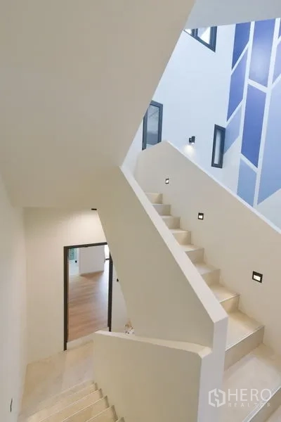 Home Office for rent or sale - White staircase with modern lighting beside a blue geometric feature wall.