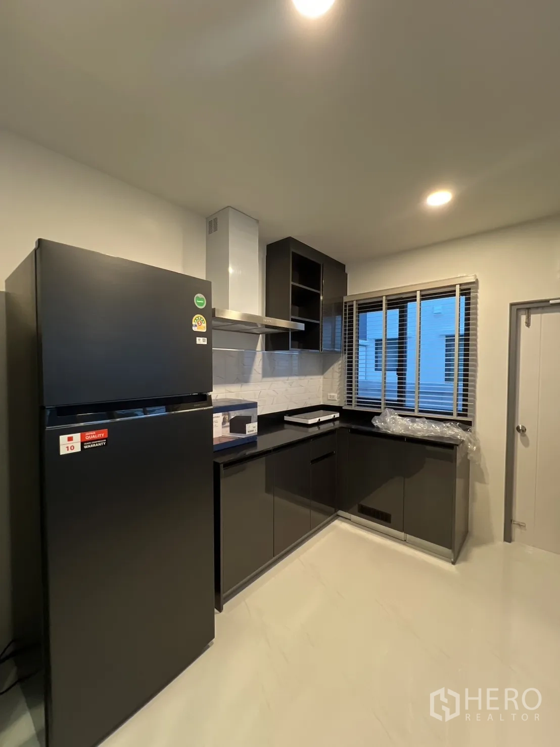 บ้าน ให้เช่าในBang Phli, Samut Prakan - ห้องครัวสมัยใหม่ ตู้ลามิเนตสีดำ ตู้เย็น และเครื่องดูดควัน