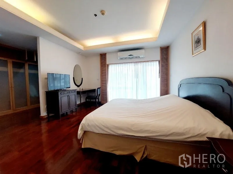 อพาร์ทเมนท์ ให้เช่า - ห้องนอนหลัก เตียงคิง ตู้วางทีวี โต๊ะทำงาน ประตูกระจกออกระเบียง และเครื่องปรับอากาศ