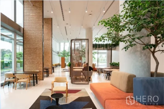 สำนักงาน ให้เช่าในChatuchak, Bangkok - พื้นที่สังคมชั้นล่างแบบคาเฟ่ที่นั่งหลากหลายและต้นไม้ในอาคาร ใกล้หน้าต่างสูง