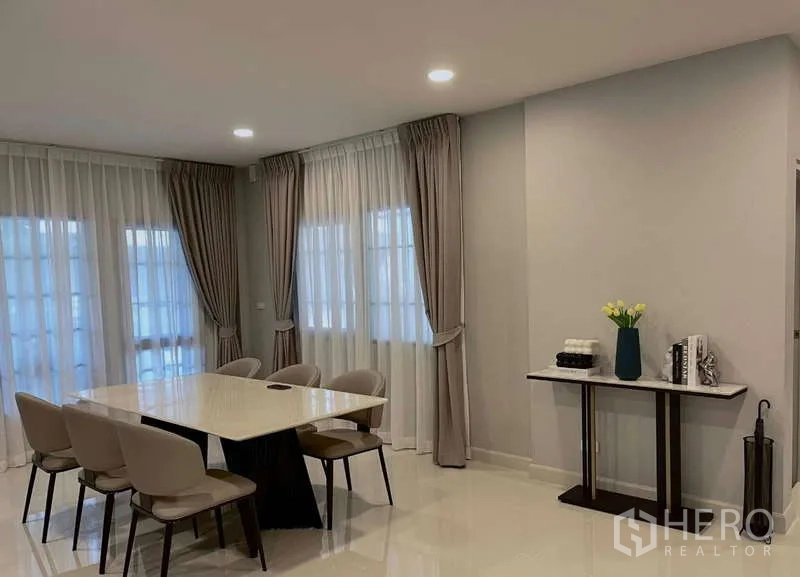 Detached House for rent in Bang Phli, Samut Prakan - Dining area with six-seat table beside full-height windows and curtains