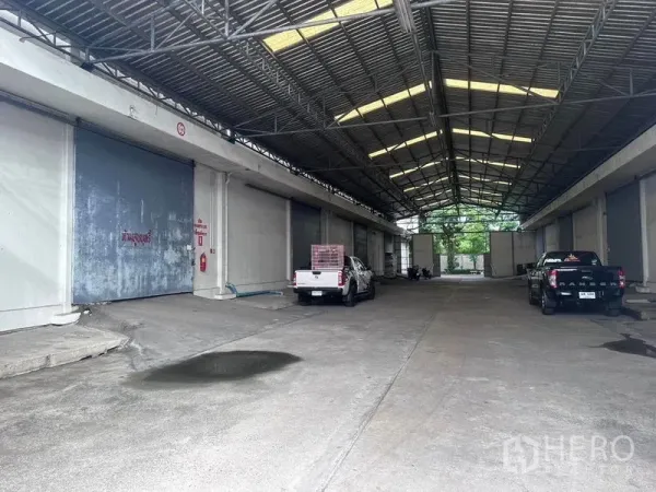 คลังสินค้า ให้เช่าในMueang Samut Prakan, Samut Prakan - ท่าขนถ่ายสินค้ามีหลังคาแบบขับผ่านได้ พร้อมประตูม้วนขนาดใหญ่หลายบานและรถกระบะจอด