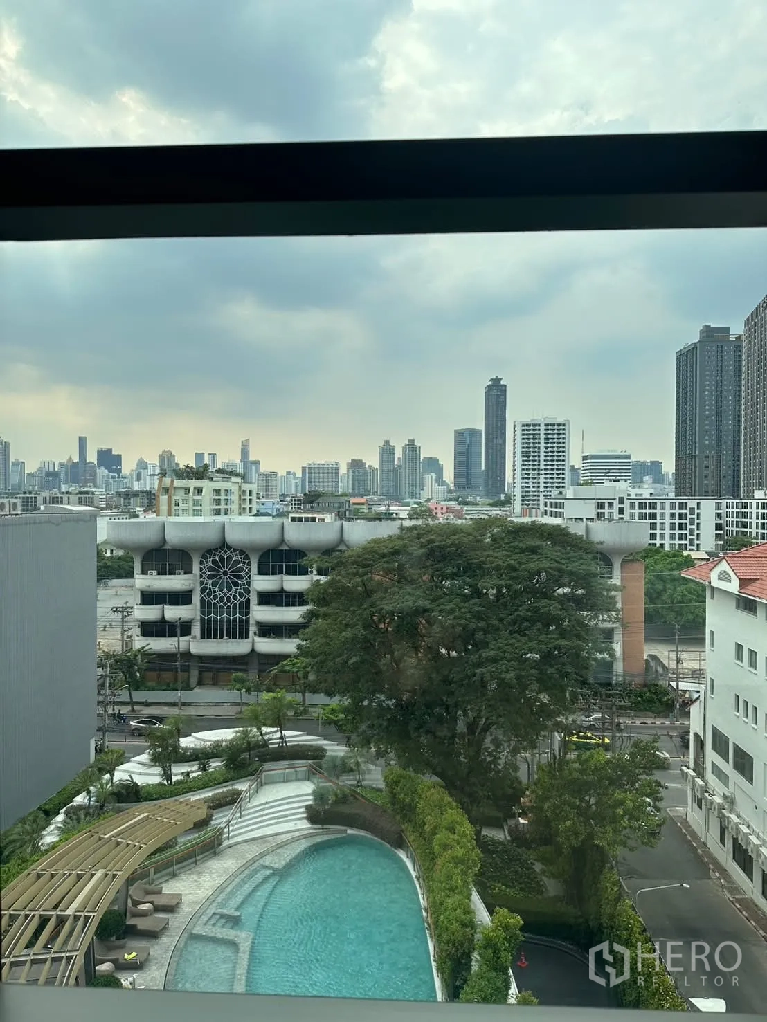 Condominium for rent or sale in Watthana, Bangkok - City skyline and landscaped swimming pool view from the unit.