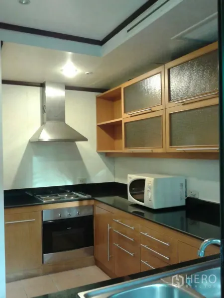 Detached House for rent in Suan Luang, Bangkok - Modern U-shaped kitchen with stainless oven, cooktop, range hood, and ample storage.