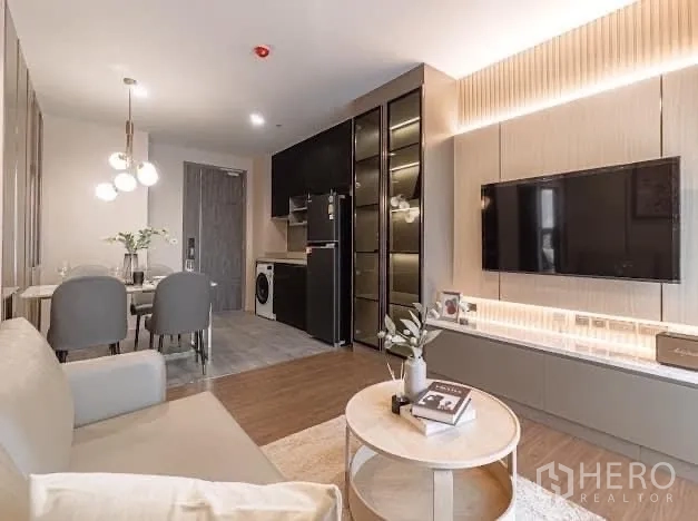 Condominium for rent in Watthana, Bangkok - Open living space with sofa, round coffee table and dining set.