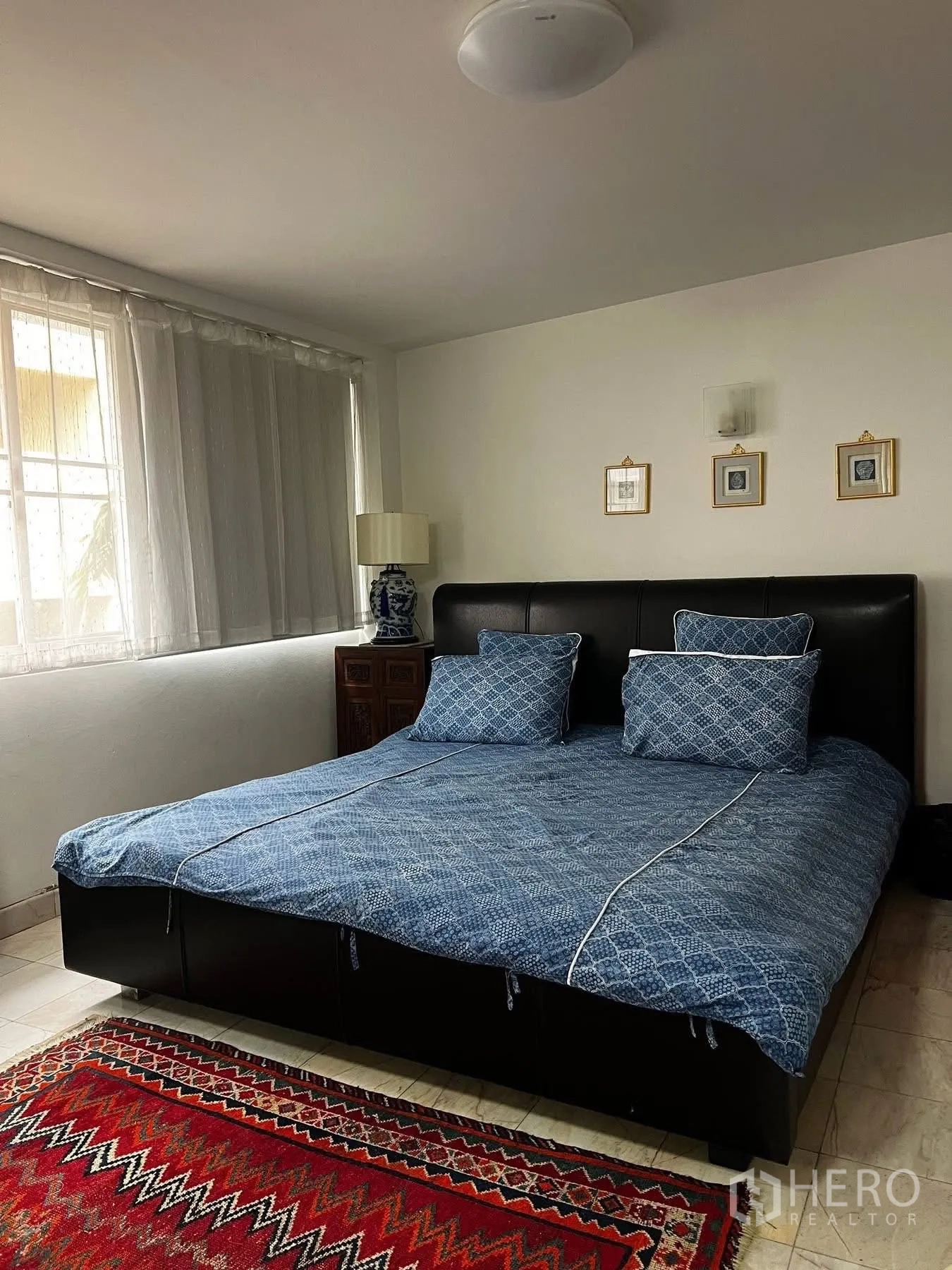 ทาวน์เฮาส์ for rent or sale in Watthana, Bangkok - ห้องนอนเตียงคู่ ผ้าปูสีน้ำเงิน หน้าต่างบานใหญ่และพรมสีสัน