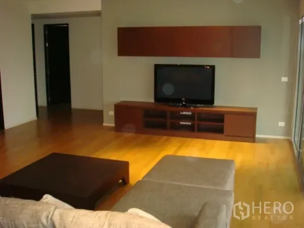 คอนโด ให้เช่าในWatthana, Bangkok - ผนังทีวีพร้อมชั้นวางเตี้ยและพื้นไม้ในโซนนั่งเล่น