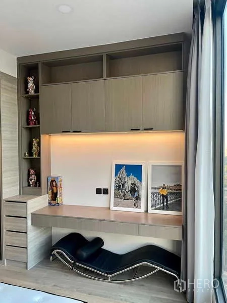 Condominium for rent - Built-in study nook with overhead cabinets, accent lighting and lounge chair beside a floor-to-ceiling window.