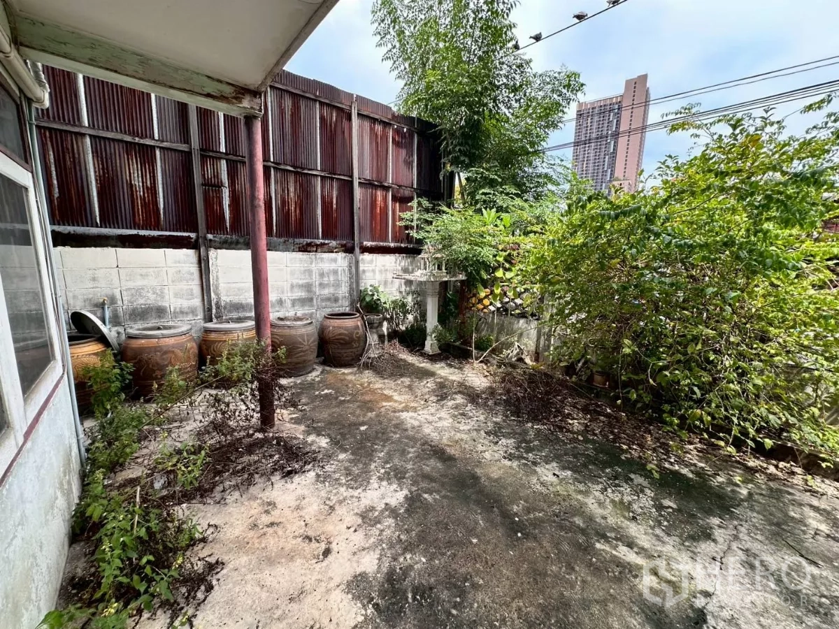 零售空间 出租在Khlong Toei, Bangkok - 水泥庭院，有绿植，远处可见城市高楼