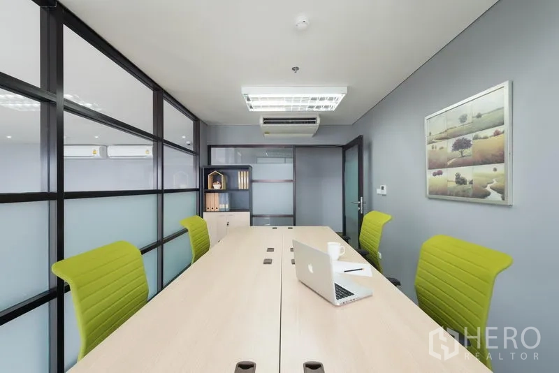 办公空间 出租在Chatuchak, Bangkok - 玻璃隔断的会议室，长会议桌、亮绿色椅子与顶置空调，现代化办公室。
