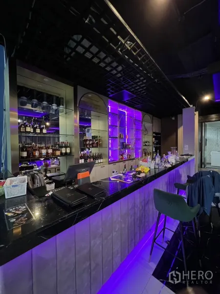 พื้นที่ขายปลีก ให้เช่า - เคาน์เตอร์บาร์หินอ่อนสีดำ พร้อมชั้นวางหลังบาร์ไฟ LED สีม่วง