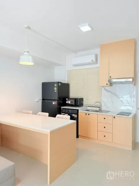 Townhouse for rent in Bang Phli, Samut Prakan - Bright kitchen with light wood cabinets, marble-look backsplash, and breakfast island.