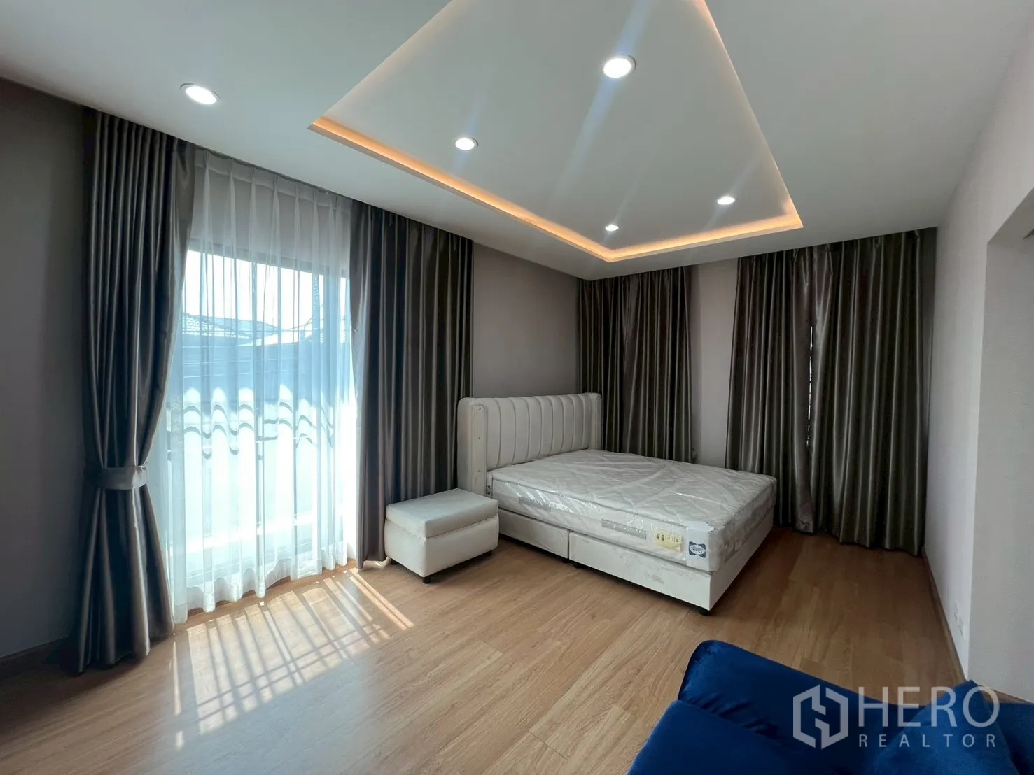 Detached House for rent or sale in Bang Phli, Samut Prakan - Sunny bedroom with floor-to-ceiling windows, sheer curtains and upholstered bed.