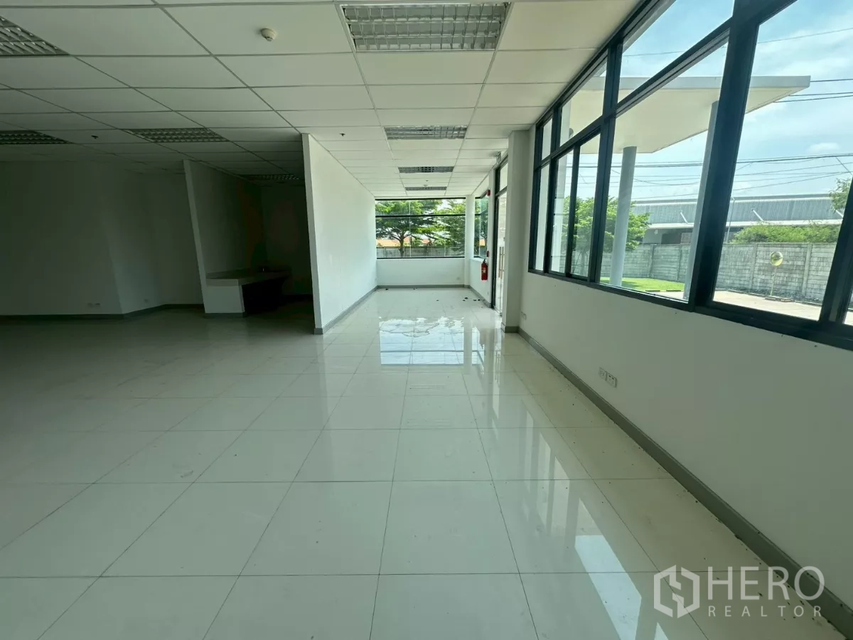 Warehouse for rent in Bang Phli, Samut Prakan - Open-plan office space with suspended ceiling and glossy ceramic tiles.