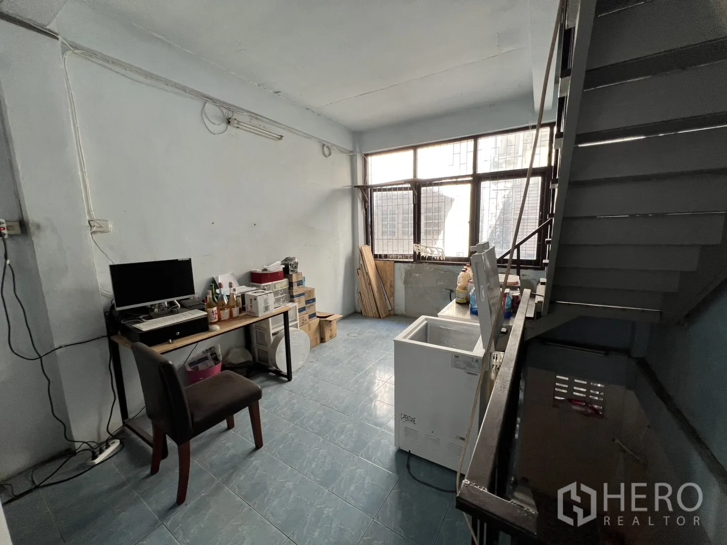 อาคารพาณิชย์ ให้เช่าหรือขาย - มุมทำงานข้างบันได มีตู้แช่และโต๊ะคอมพิวเตอร์ ใต้หน้าต่างกว้าง