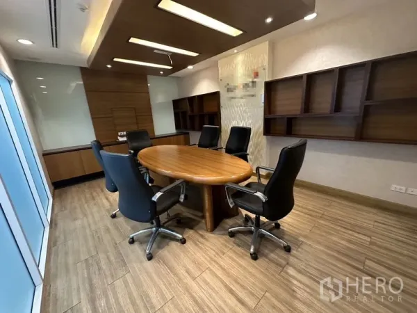 Office Space for rent or sale - Another angle of the oval-table meeting room with wall-mounted shelves.