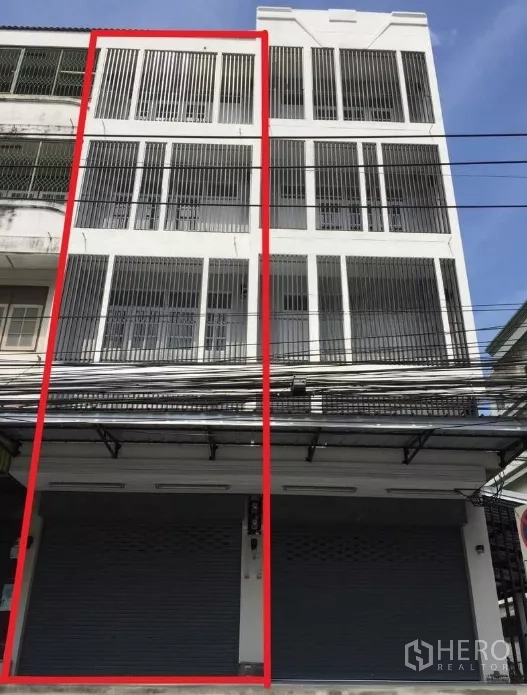 店屋 出租在Suan Luang, Bangkok - 四层白色临街商住楼外立面，带金属卷闸门与竖向护栏，位于On Nut区域。