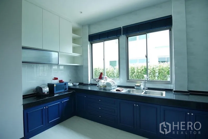 บ้าน ให้เช่าในLat Krabang, Bangkok - ครัวไทยตู้สีน้ำเงิน เคาน์เตอร์หินเข้ม และหน้าต่างคู่