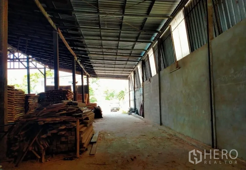 Warehouse for sale in Mueang Nonthaburi, Nonthaburi - Secure sliding metal gate and perimeter wall on a quiet road with office building inside.