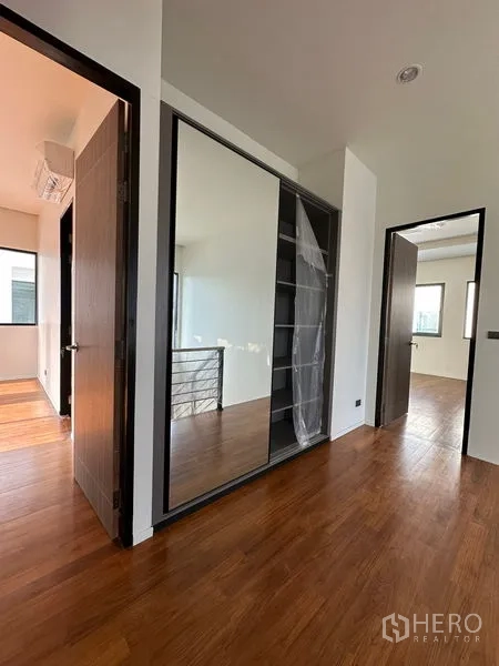 บ้าน ให้เช่าในWatthana, Bangkok - โถงชั้นบนพร้อมตู้บิลท์อินกระจกเงาและพื้นไม้ เชื่อมสู่ห้องนอน