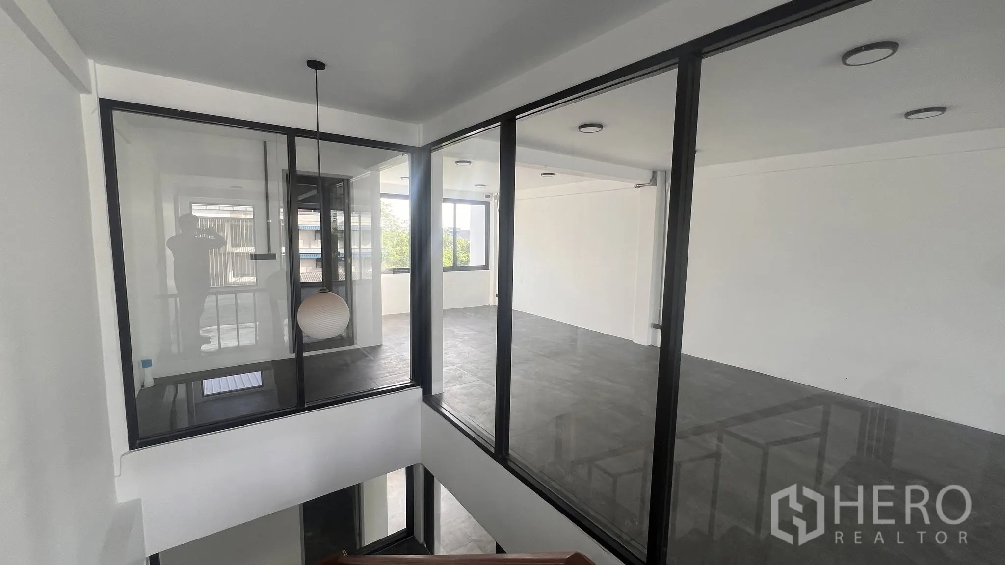 โฮมออฟฟิศ for rent or sale in Phra Khanong, Bangkok - ชั้นลอยผนังกระจกพร้อมโคมแขวน มองเห็นโถงบันได.