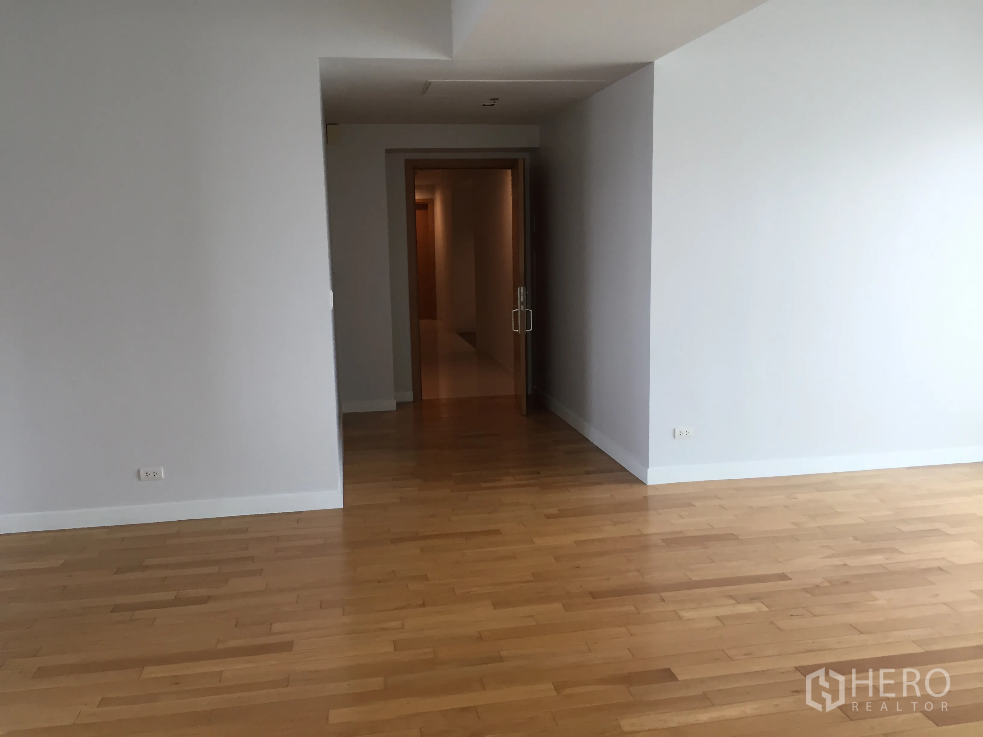 คอนโด ให้เช่าในKhlong Toei, Bangkok - พื้นที่นั่งเล่นกว้าง พื้นไม้สีอ่อน และทางเดินสู่โถงภายใน.