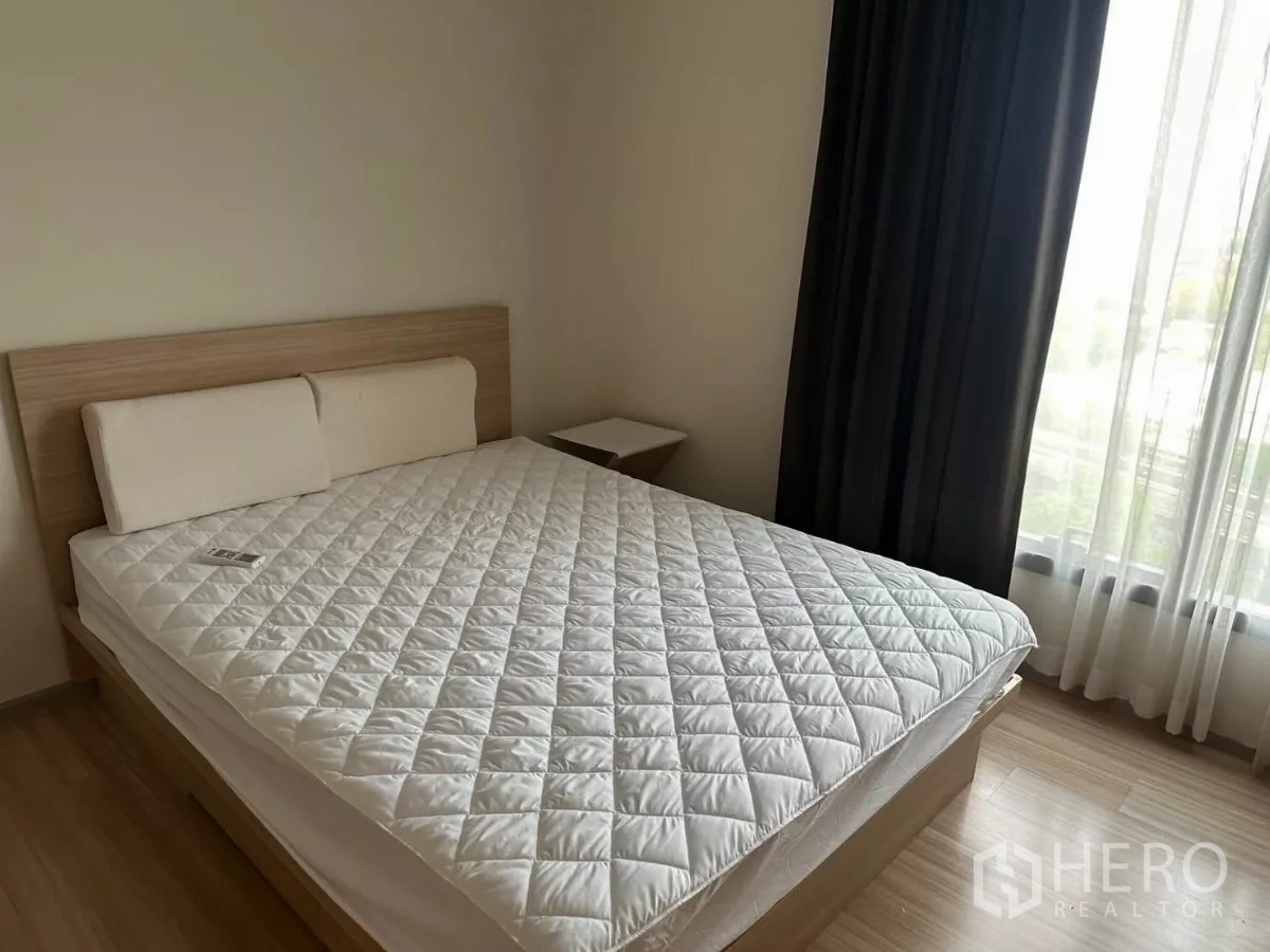 คอนโด ให้เช่าในChatuchak, Bangkok - ห้องนอนหลักเตียงควีน ผ้าม่านทึบแสง พื้นไม้ และหน้าต่างบานใหญ่