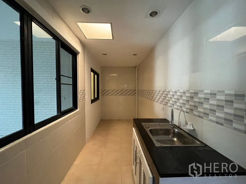 ทาวน์เฮาส์ ให้เช่าหรือขายในKhlong Toei, Bangkok - ครัวไทยทรงยาวพร้อมอ่างล้างจานคู่ ผนังกระเบื้องและแผงโมเสก