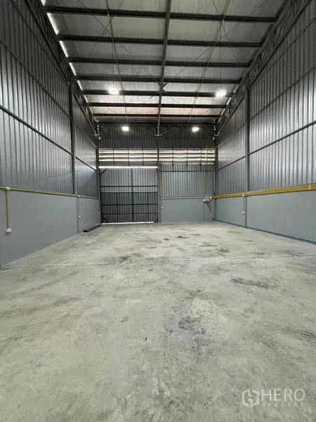 货栈 出租在Mueang Pathum Thani, Pathum Thani - 仓库作业区，混凝土地坪，尽端为大型装卸门。