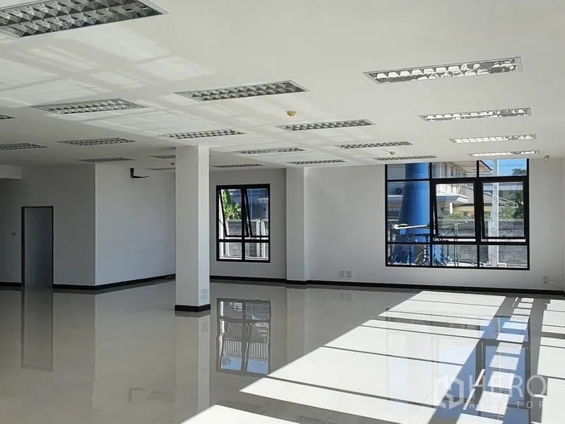 Warehouse for rent in Samut Prakan - Bright office interior with tiled floors, grid lighting and multiple windows.