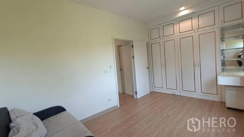 联排别墅 出租 - 卧室铺木地板，内置白色衣柜与梳妆台。