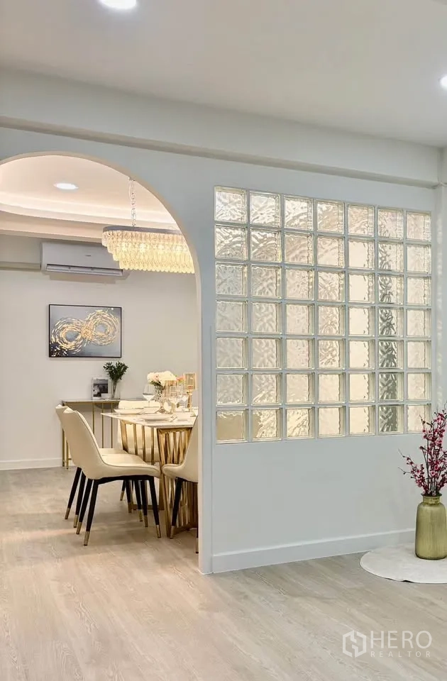 独栋房屋 for rent in Huai Khwang, Bangkok - 餐区带拱形开口与玻璃砖隔断，木色地面明亮。