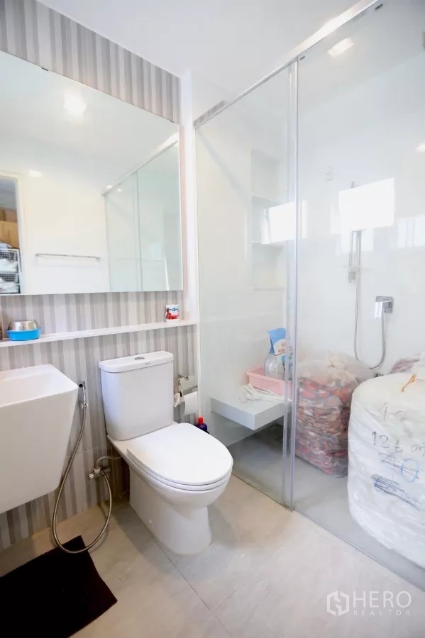 Detached House for rent in Samut Prakan - Modern bathroom with glass shower enclosure, smart toilet and marble tiles.
