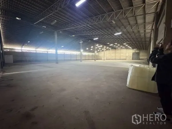 Warehouse for rent - Open storage hall with high roof, support columns and wide floor space suitable for racking.