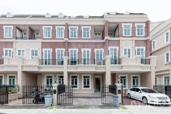 Townhouse for rent in Watthana, Bangkok - Three-storey townhouse facade in Watthana, Bangkok with brick accents, balconies and gated parking near BTS On Nut.