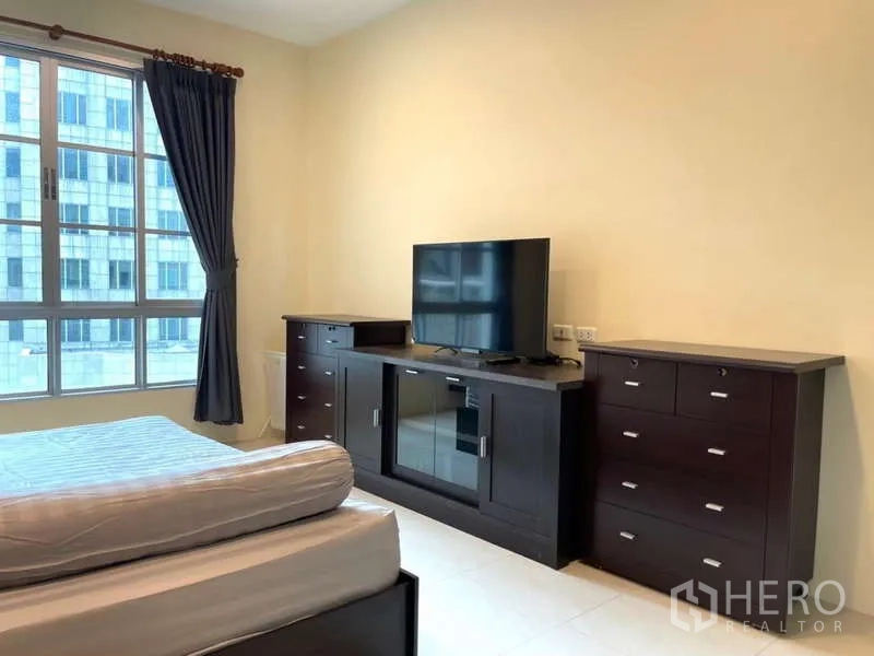 房间 出租在Khlong Toei, Bangkok - 主卧内的电视柜与抽屉柜，面向大窗