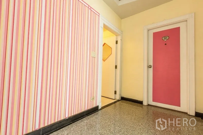 店屋 出租在Phaya Thai, Bangkok - 色彩活泼的走道，条纹墙面与粉色房门。