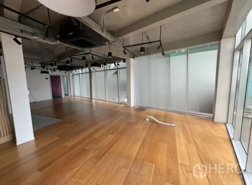 零售空间 出租在Khlong Toei, Bangkok - 宽敞展厅，木地板与通高窗。