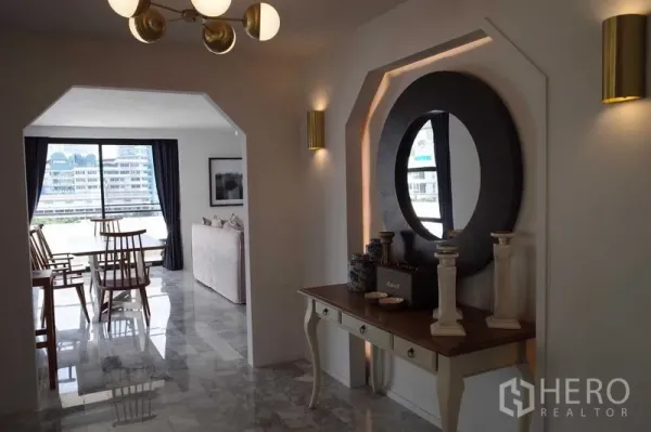 คอนโด ให้เช่าในWatthana, Bangkok - โถงทางเข้าดีไซน์โค้งพร้อมโต๊ะคอนโซลและกระจกกลม เชื่อมสู่ห้องนั่งเล่นและรับประทานอาหาร