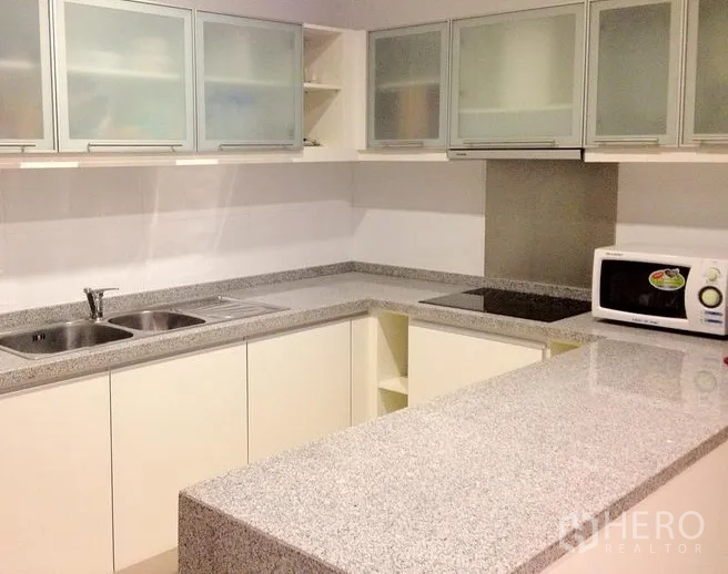 คอนโด ให้เช่าในKhlong Toei, Bangkok - ครัวรูปตัว U เคาน์เตอร์หินแกรนิต บาร์เตรียมอาหาร เตาไฟฟ้า ไมโครเวฟ และตู้แขวนกระจกฝ้า