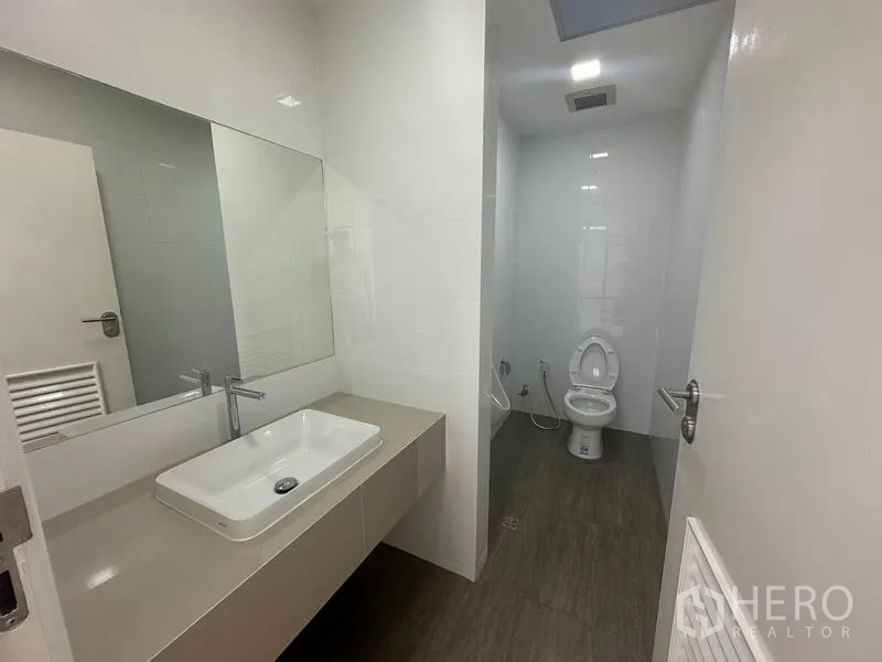 办公空间 出租 - 现代化卫生间，超大镜面、长方形台上盆与独立坐便区。