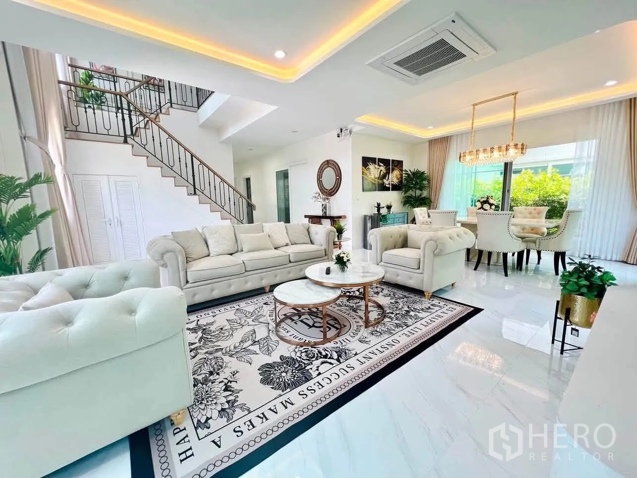 Detached House for rent in Bang Phli, Samut Prakan - Open-plan living and dining space with a staircase and floor-to-ceiling windows.