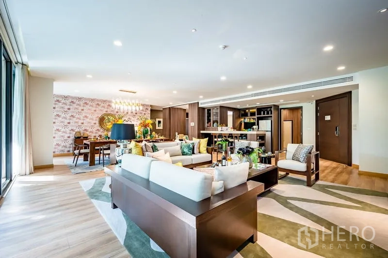Condominium for sale - Open-plan living and dining room with floor-to-ceiling windows, modern kitchen and warm wood finishes at a Watthana condo.