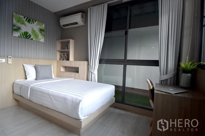 Condominium for rent in Khlong Toei, Bangkok - Second bedroom with single bed, study desk, big window and air conditioner.