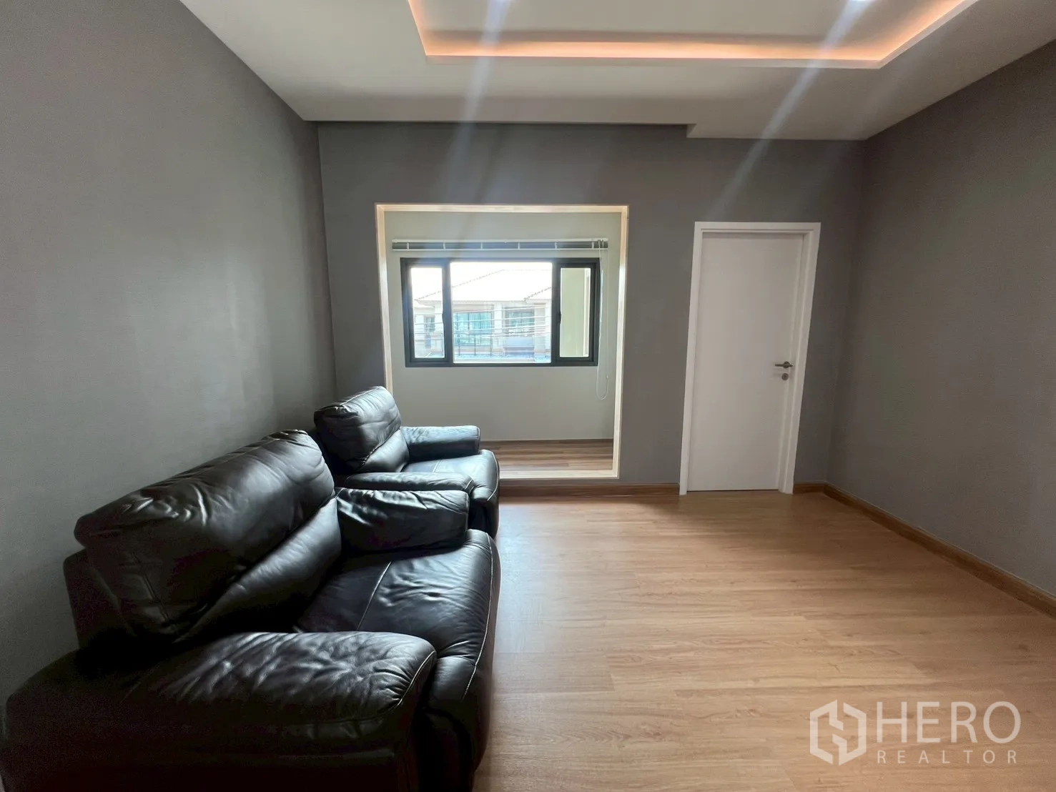 Detached House for rent or sale in Bang Phli, Samut Prakan - Upstairs family lounge with black leather sofas and window alcove.
